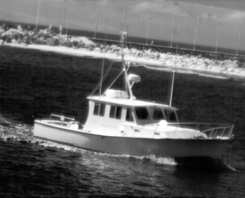 Attollo Engineering Phoenix SWIR camera core with 5 micron pixel pitch and low SWaP (Size, Weight and Power). Image of small boat in harbor.